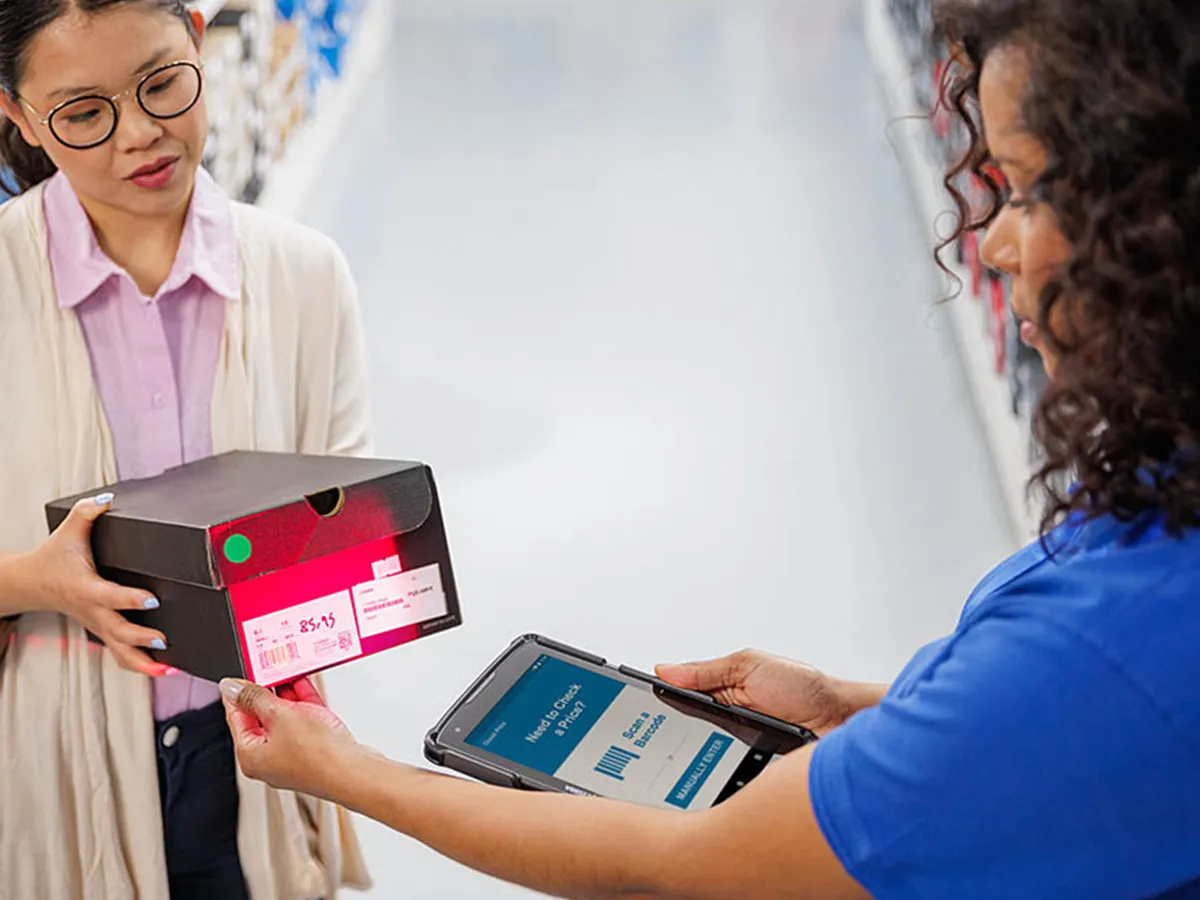 An operator checking RFID-tagged cartons on a warehouse shelf